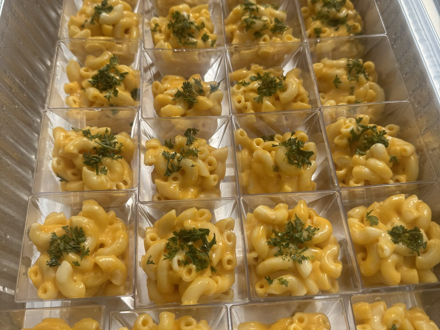 Individually portioned mac and cheese servings packed one per guest for an office lunch